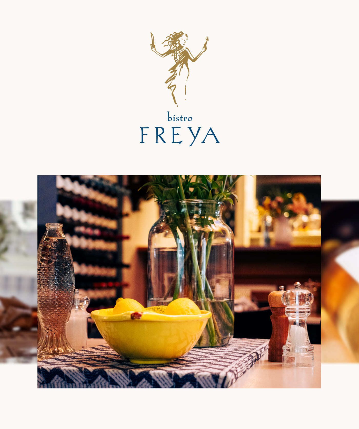 Een gele schaal met citroenen, een waterfles, een zout- en pepermolen en een grote glazen vaas op een tafel bij Bistro Freya, met bloemen en een wijnrek op de achtergrond: de perfecte inspiratie voor websites of webshops die zich richten op elegant dineren.